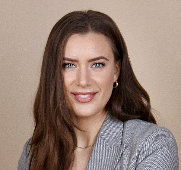 Ebony Bowden, a woman with long dark brown hair, smiling towards the camera.